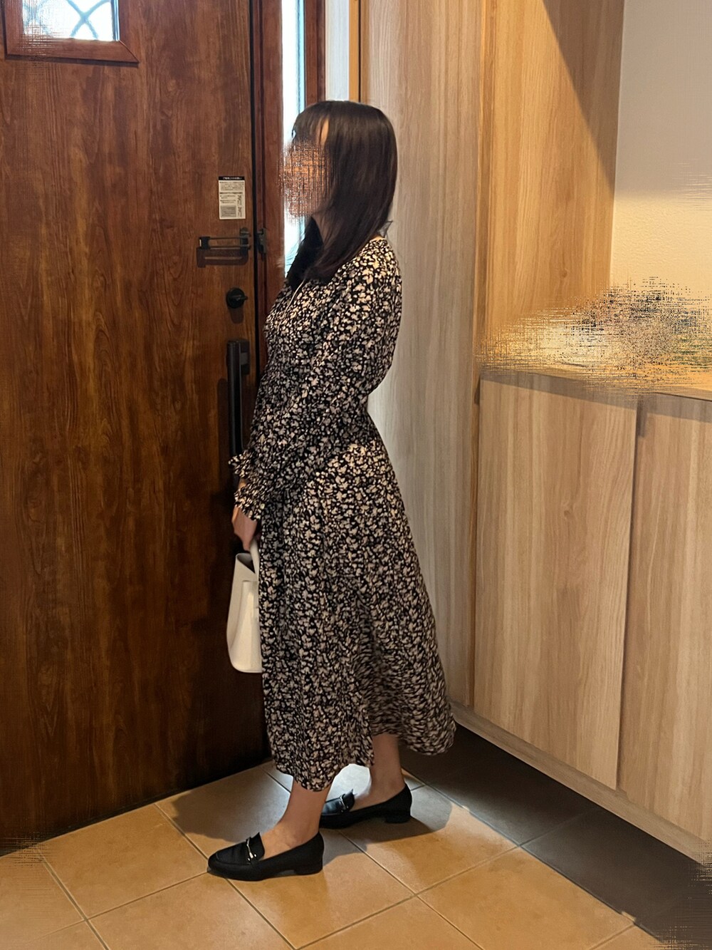 ブラック系のワンピース、ブラック系のローファー、ホワイト系のショルダーバッグを着用したレディースの秋コーディネートの2枚目の写真