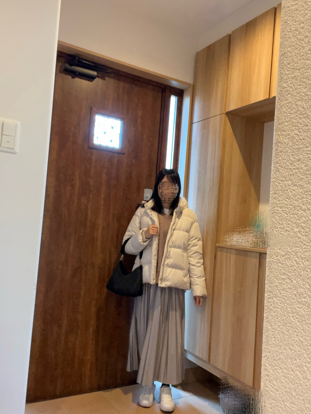 ピンク系のニット/セーター、ホワイト系のショルダーバッグ、グレー系のスカートを着用したレディースの冬コーディネートの2枚目の写真