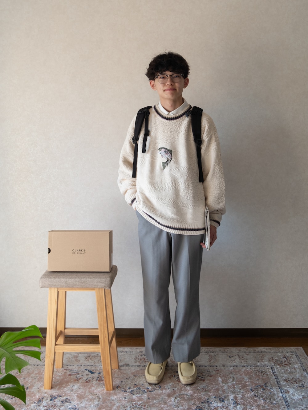 ベージュ系のモカシン/デッキシューズ、ベージュ系のニット/セーター、ブラック系のバックパック/リュックを着用したメンズの冬コーディネートの3枚目の写真