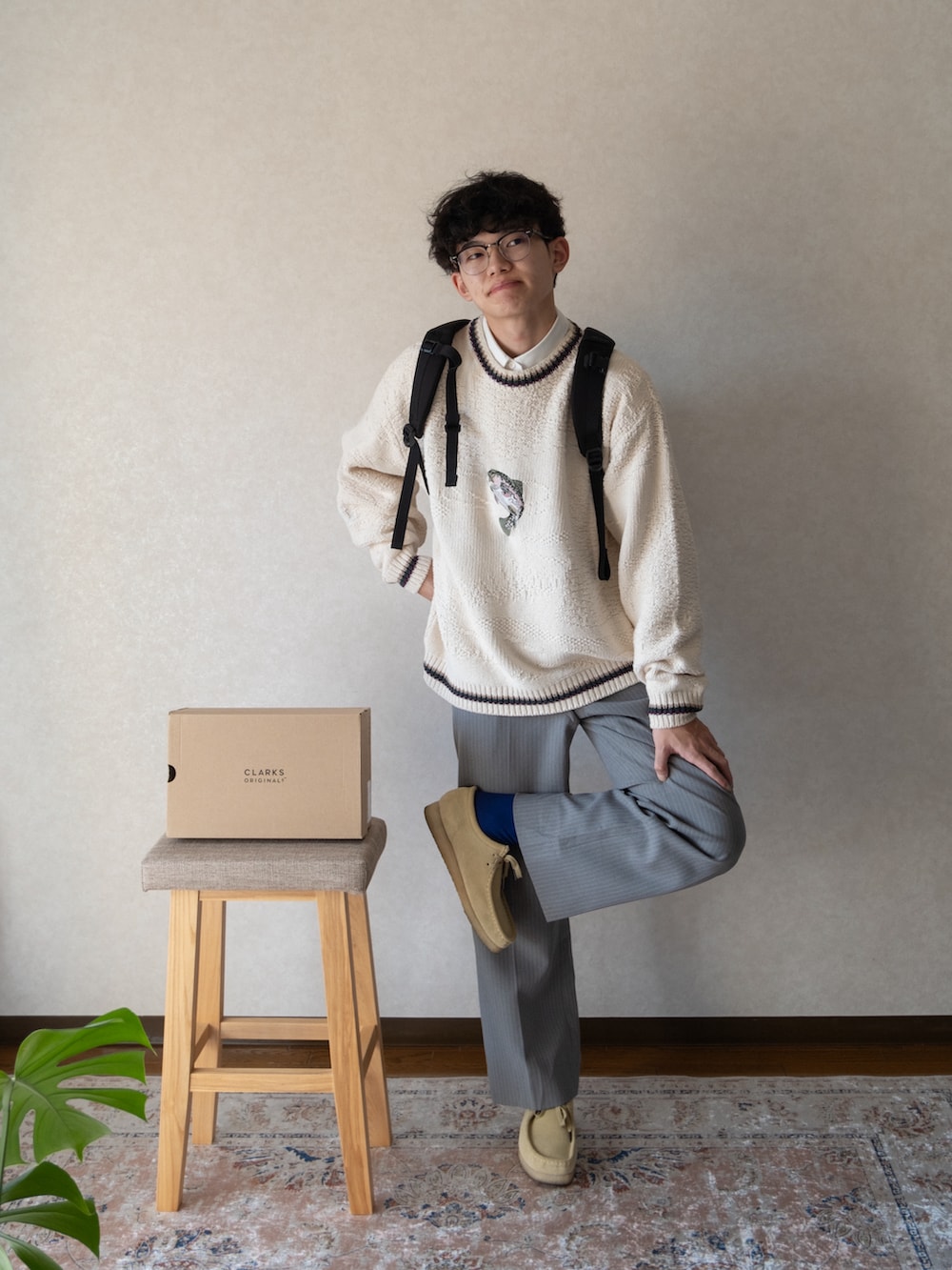 ベージュ系のモカシン/デッキシューズ、ベージュ系のニット/セーター、ブラック系のバックパック/リュックを着用したメンズの冬コーディネートの2枚目の写真