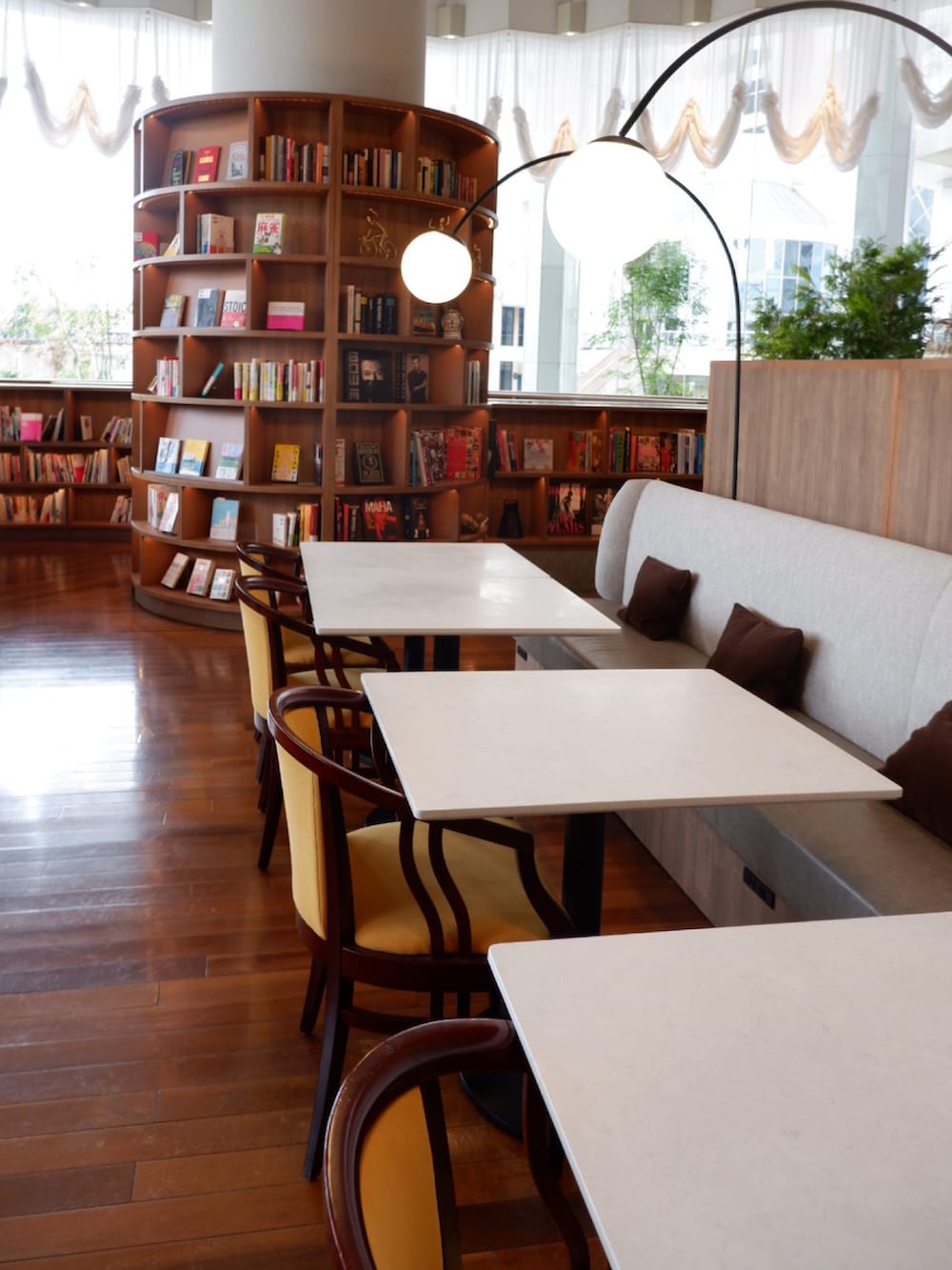 ブラウン系のレインシューズ、ブラウン系のチェスターコート、ベージュ系のショルダーバッグを着用したメンズの秋コーディネートの3枚目の写真