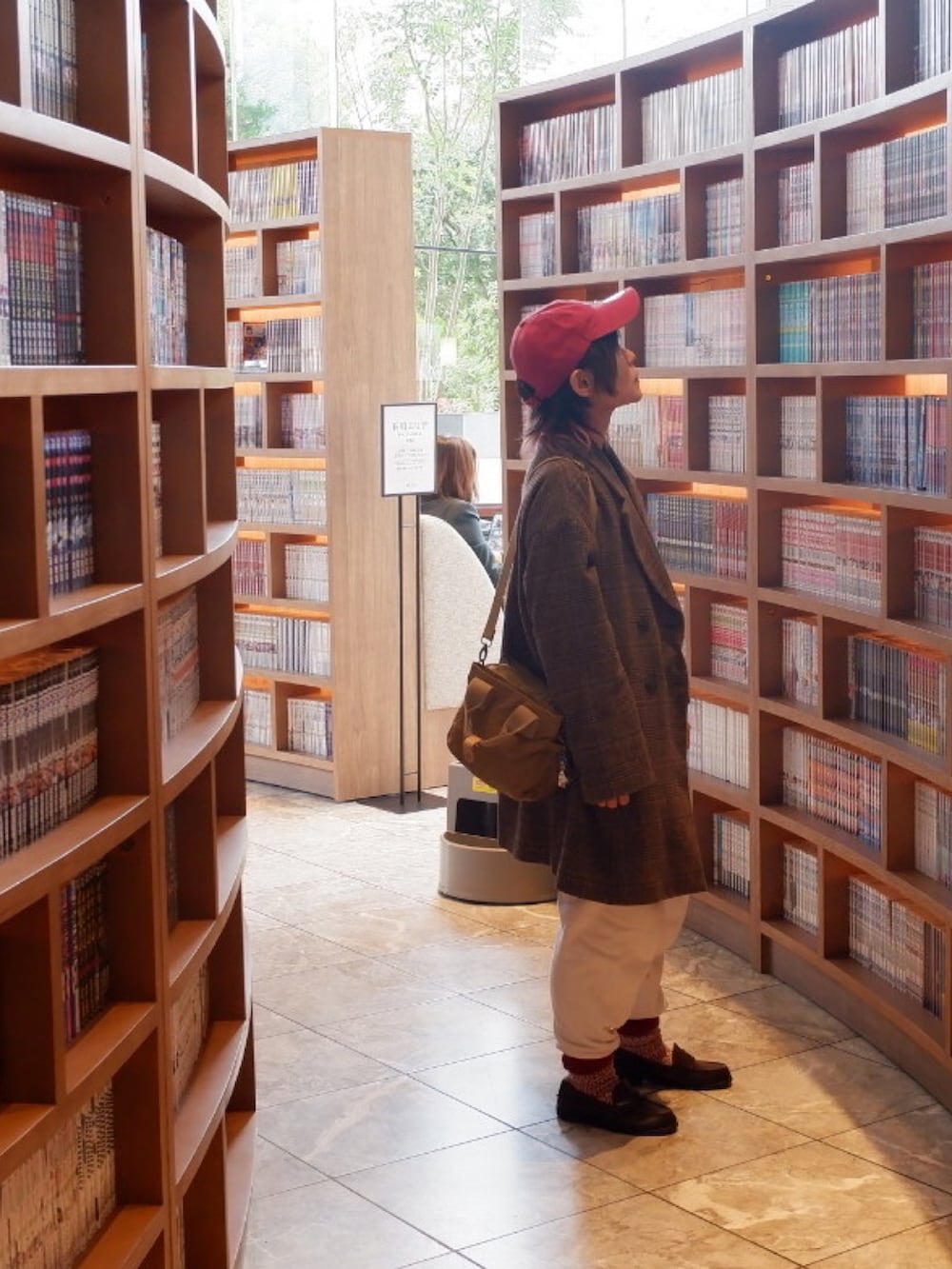 ブラウン系のレインシューズ、ブラウン系のチェスターコート、ベージュ系のショルダーバッグを着用したメンズの秋コーディネートの5枚目の写真