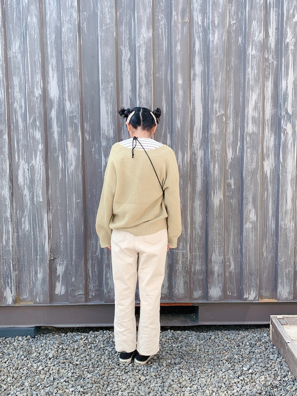 ブラック系のスニーカー、ベージュ系のデニムパンツ、グリーン系のカーディガン/ボレロを着用したキッズの冬コーディネートの2枚目の写真