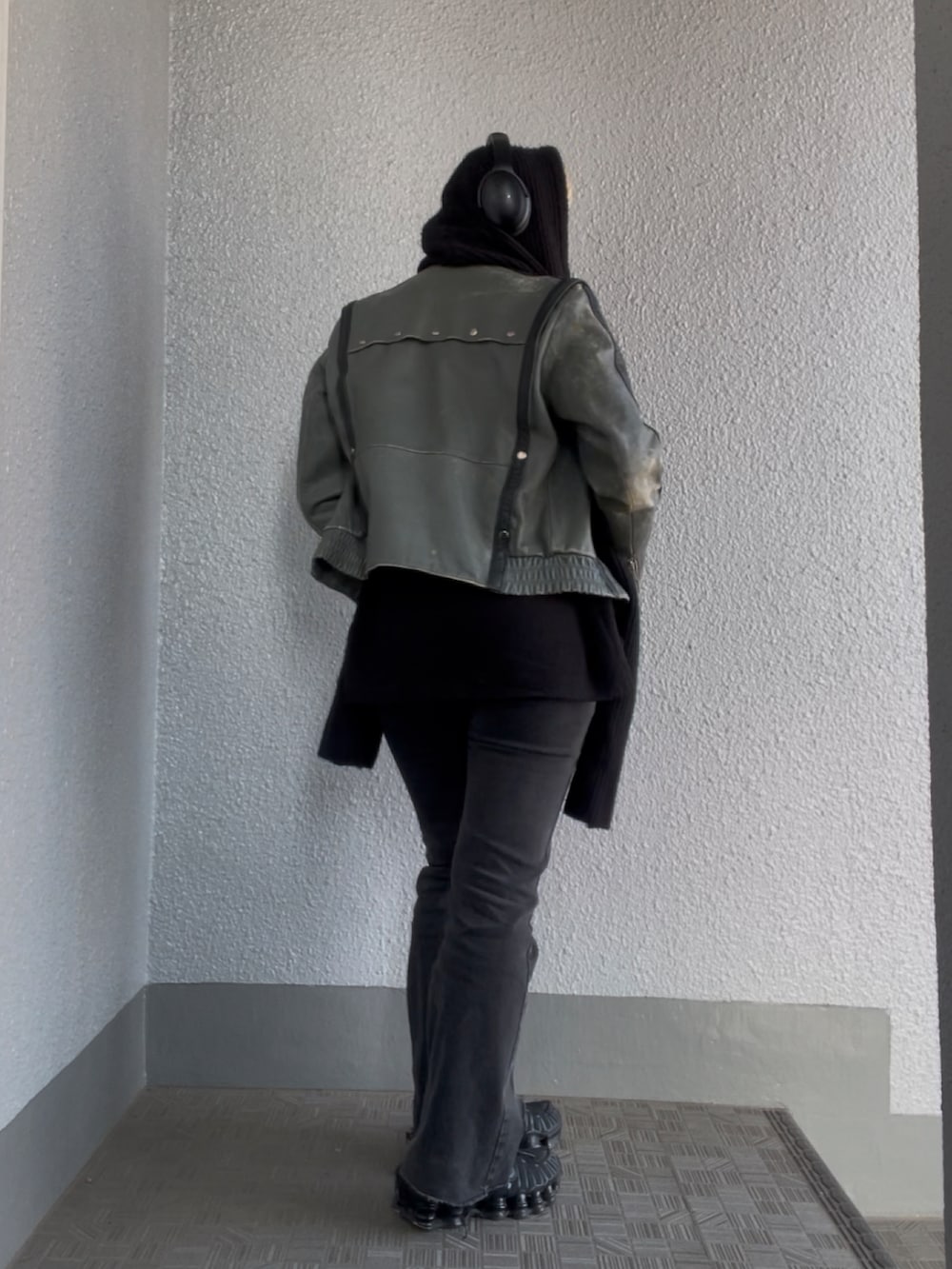 グリーン系のライダースジャケット、ブラック系のデニムパンツを着用したレディースの春コーディネートの2枚目の写真