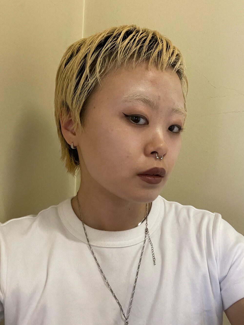 ブラウン系のデニムパンツ、ホワイト系のTシャツ/カットソー、ブラック系のスニーカーを着用したレディースの夏コーディネートの2枚目の写真