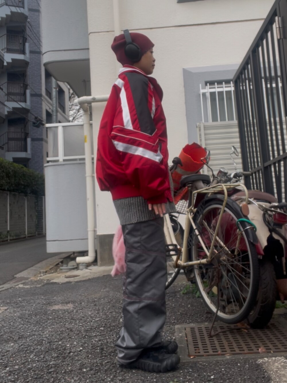 レッド系のブルゾン、グレー系のその他パンツ、ブラック系のスニーカーを着用したレディースの冬コーディネートの2枚目の写真