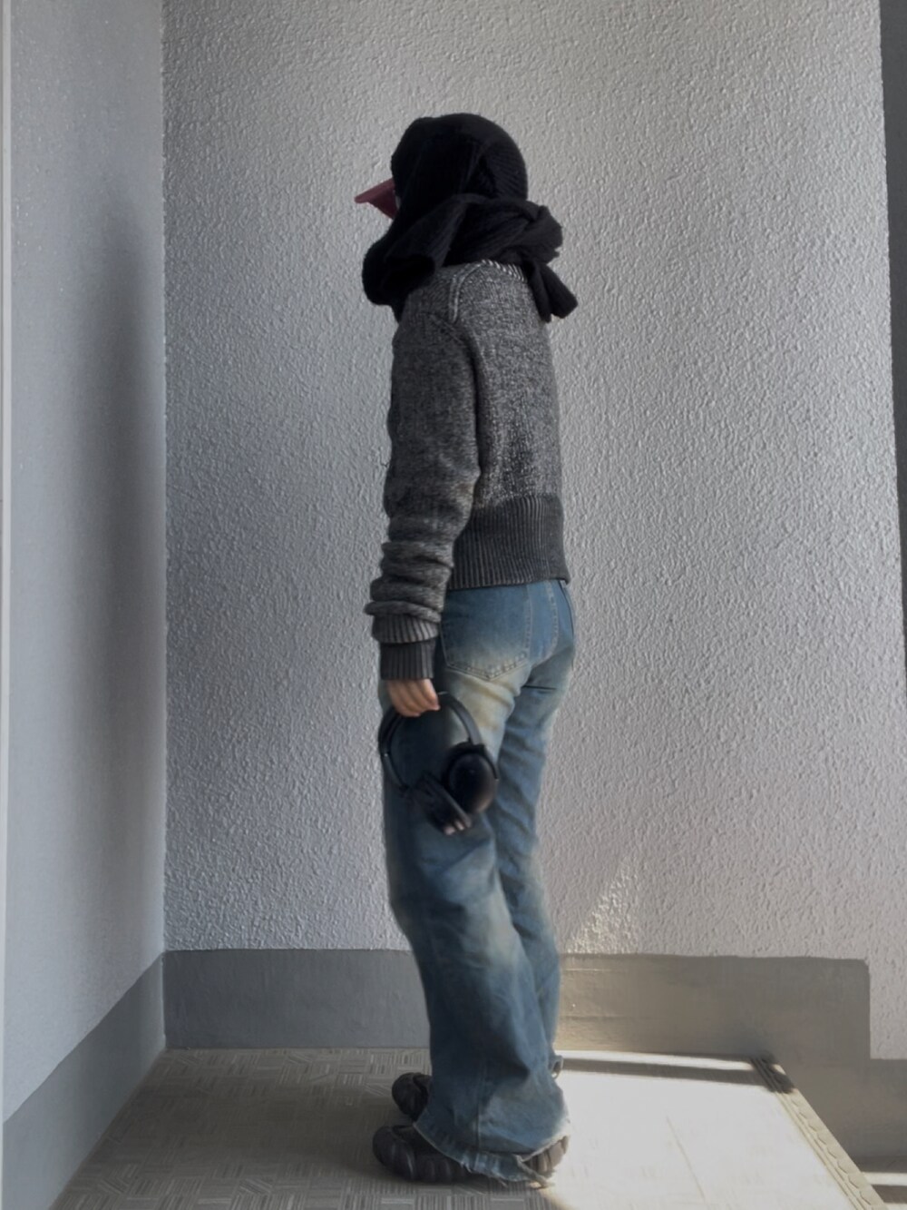ブルー系のデニムパンツ、ブラック系のスニーカー、レッド系のキャップを着用したレディースの春コーディネートの2枚目の写真