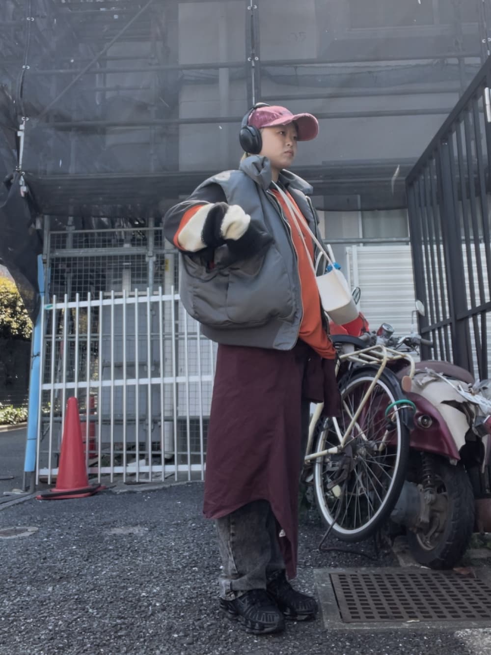 ブラウン系のデニムパンツ、ブラック系のスニーカー、ブラック系のニット/セーターを着用したレディースの春コーディネートの2枚目の写真