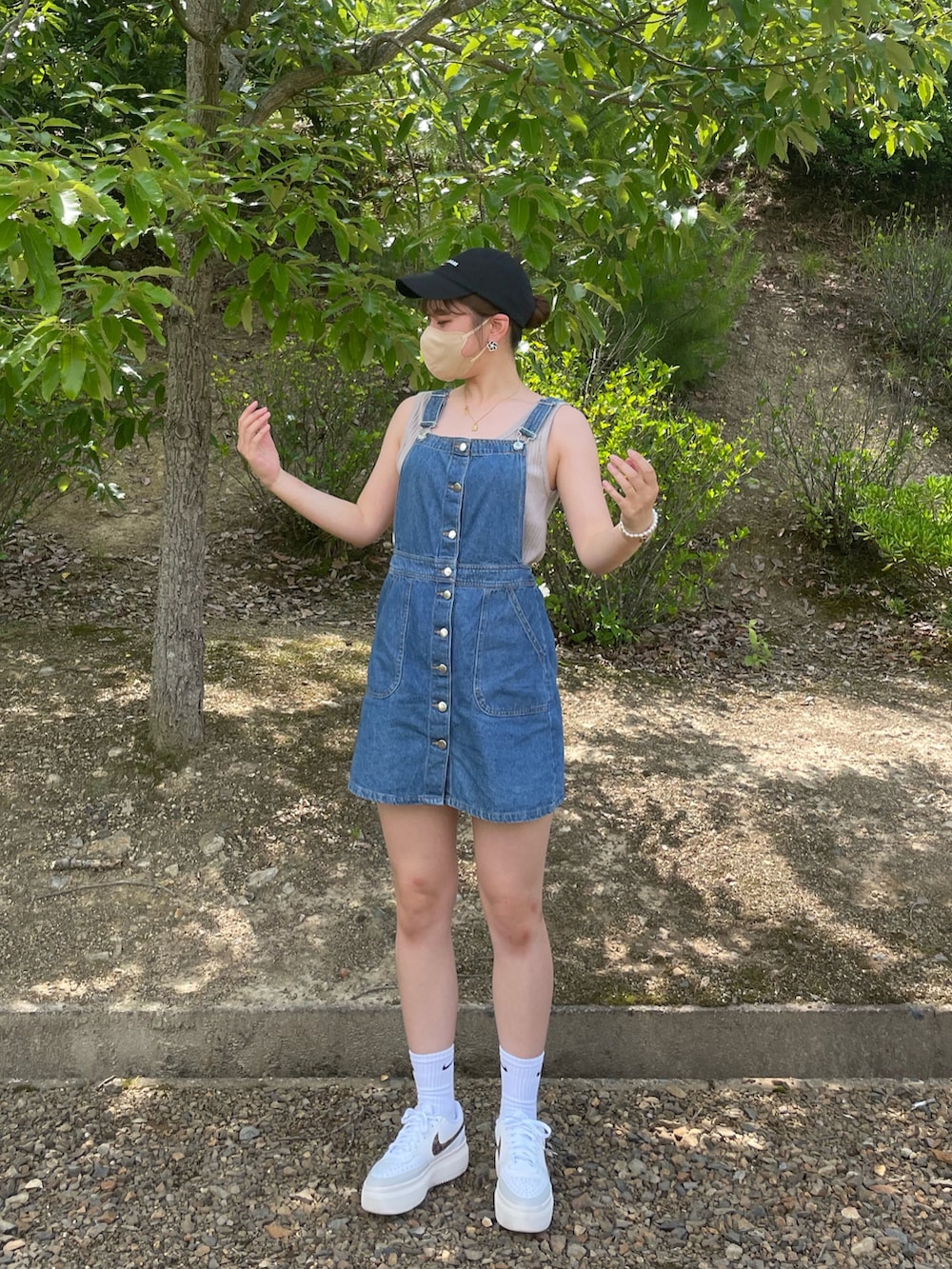 ブルー系のオールインワン・サロペット、ホワイト系のスニーカーを着用したレディースの夏コーディネートの2枚目の写真