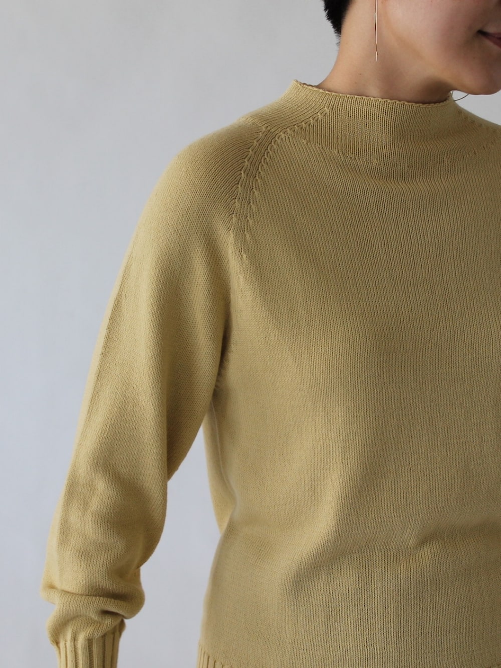 グリーン系のスカート、グリーン系のワンピース、イエロー系のニット/セーターを着用したレディースの冬コーディネートの4枚目の写真