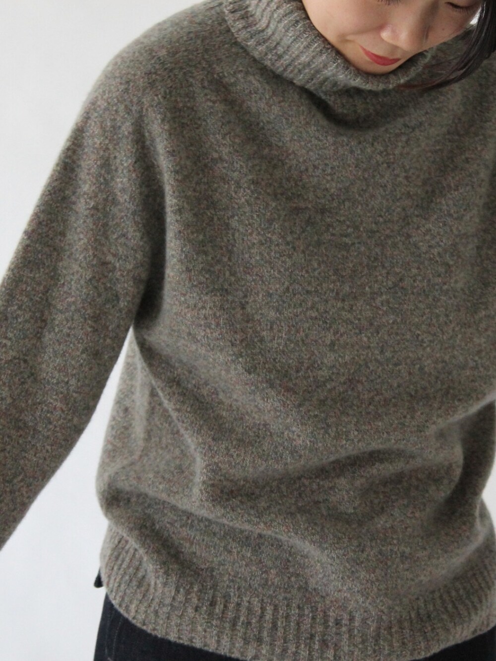 グレー系のニット/セーター、ブルー系のデニムパンツを着用したレディースの冬コーディネートの4枚目の写真