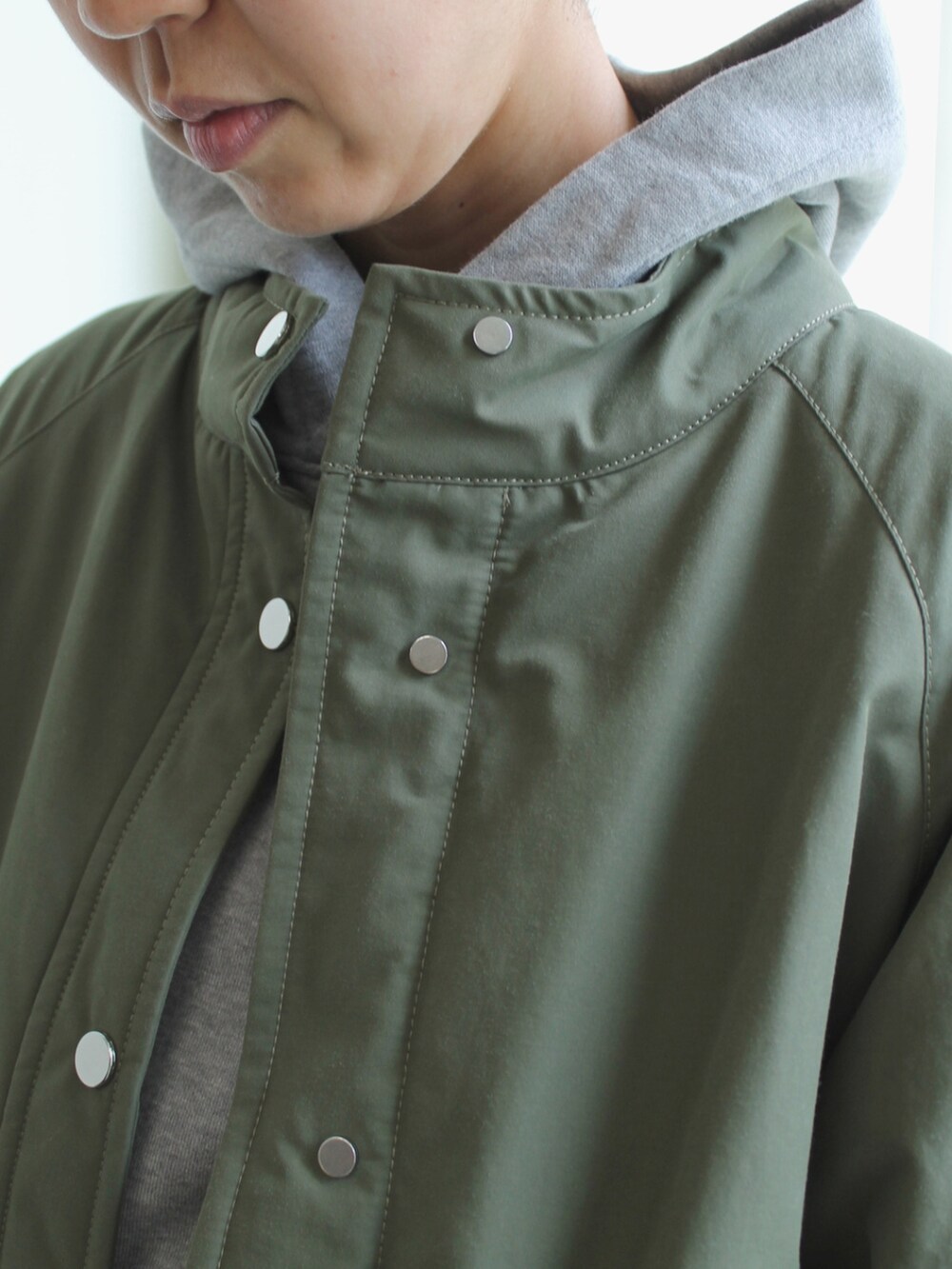 グリーン系のジャケット/アウター、ホワイト系のスカート、グレー系のパーカーを着用したレディースの秋コーディネートの3枚目の写真