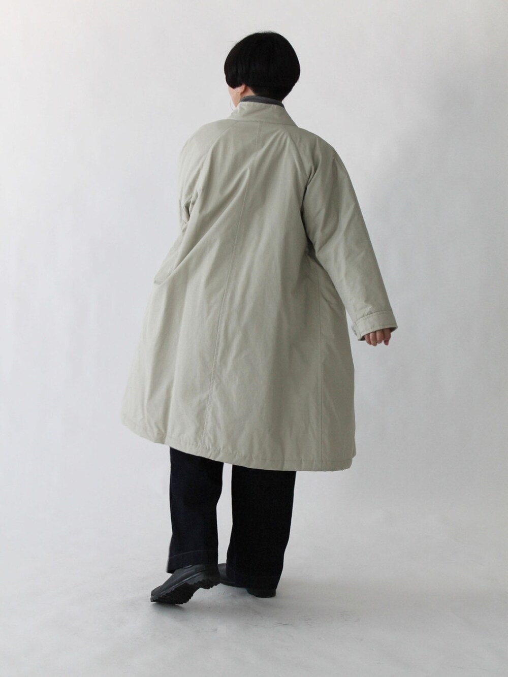 グリーン系のニット/セーター、ブルー系のデニムパンツ、ベージュ系のその他アウターを着用したレディースの秋コーディネートの2枚目の写真