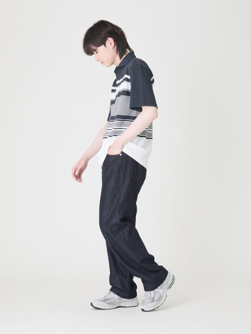 ブルー系のデニムパンツ、ブルー系のポロシャツ、グレー系のスニーカーを着用したメンズの夏コーディネートの2枚目の写真