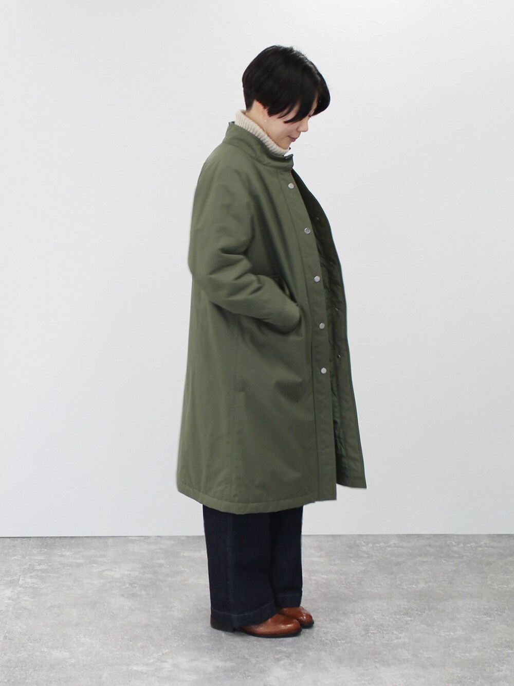 ベージュ系のニット/セーター、グリーン系のその他アウター、ブルー系のデニムパンツを着用したレディースの秋コーディネートの3枚目の写真