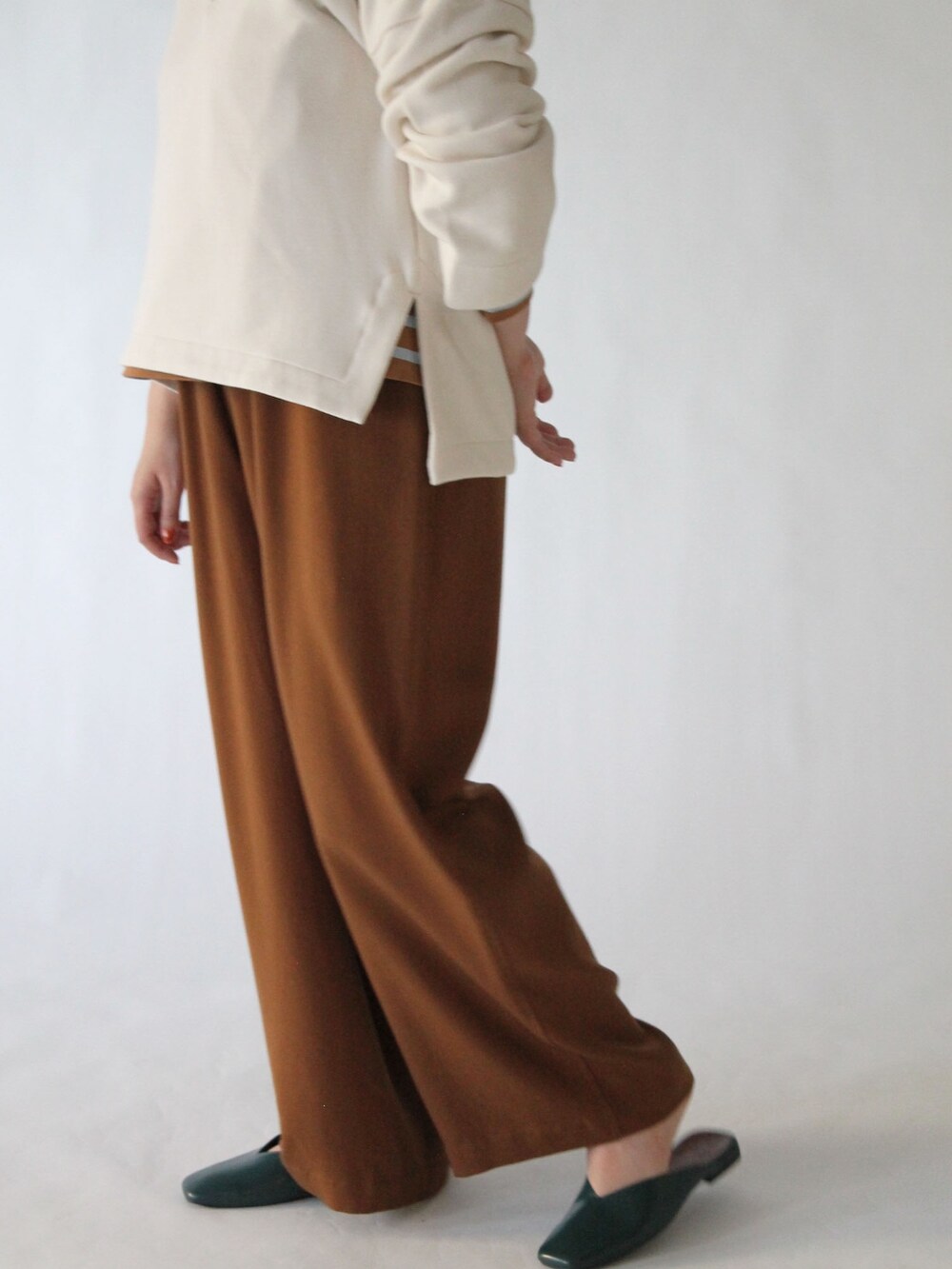 ベージュ系のスウェット、イエロー系のTシャツ/カットソー、ブラウン系のパンツを着用したレディースの春コーディネートの2枚目の写真