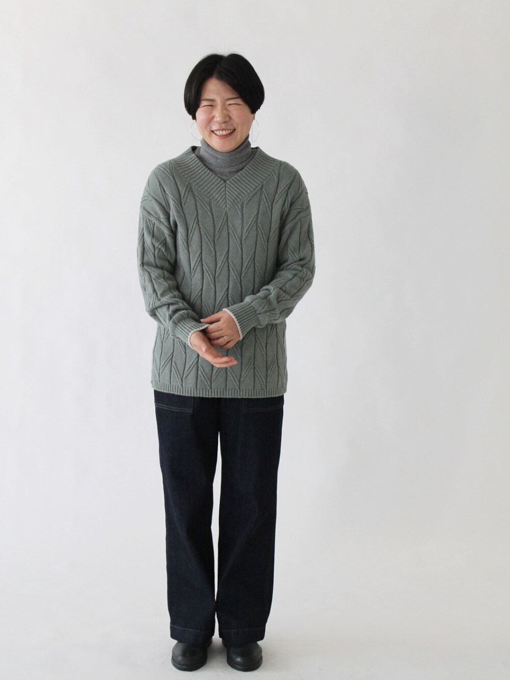 グリーン系のニット/セーター、ブルー系のデニムパンツ、ベージュ系のその他アウターを着用したレディースの秋コーディネートの3枚目の写真