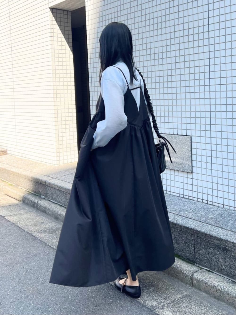 ブラック系のワンピース、ブルー系のシャツ/ブラウス、ブラック系のパンプスを着用したレディースの春コーディネートの5枚目の写真