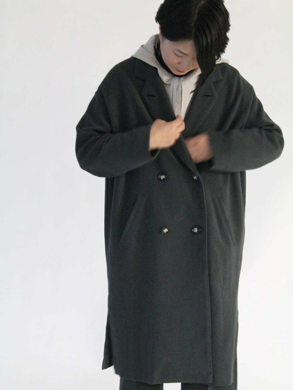 グレー系のチェスターコート、グレー系のパンツ、ベージュ系のブルゾンを着用したレディースの秋コーディネートの2枚目の写真