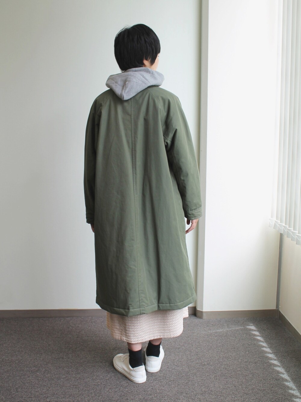 グリーン系のジャケット/アウター、ホワイト系のスカート、グレー系のパーカーを着用したレディースの秋コーディネートの4枚目の写真