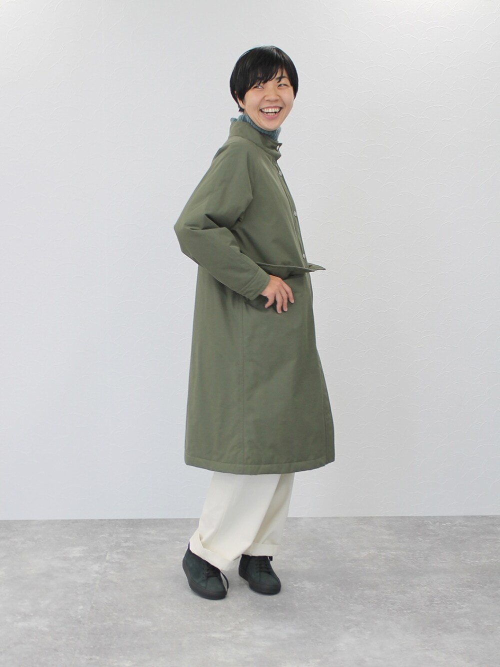 ホワイト系のパンツ、グリーン系のその他アウター、グリーン系のニット/セーターを着用したレディースの冬コーディネートの2枚目の写真