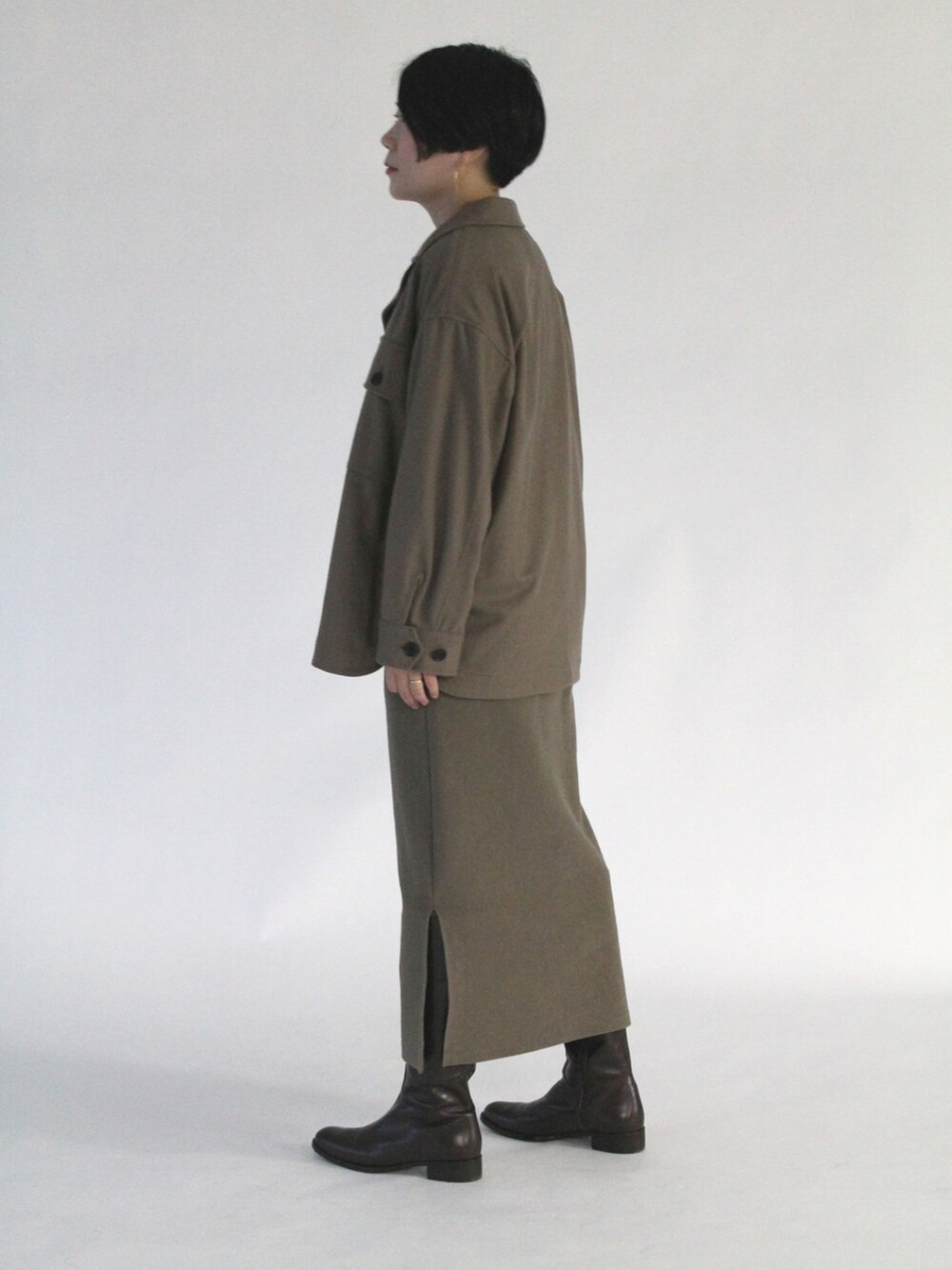 ブルー系のTシャツ/カットソー、ブラウン系のダウンジャケット/コート、グリーン系のスカートを着用したレディースの秋コーディネートの3枚目の写真