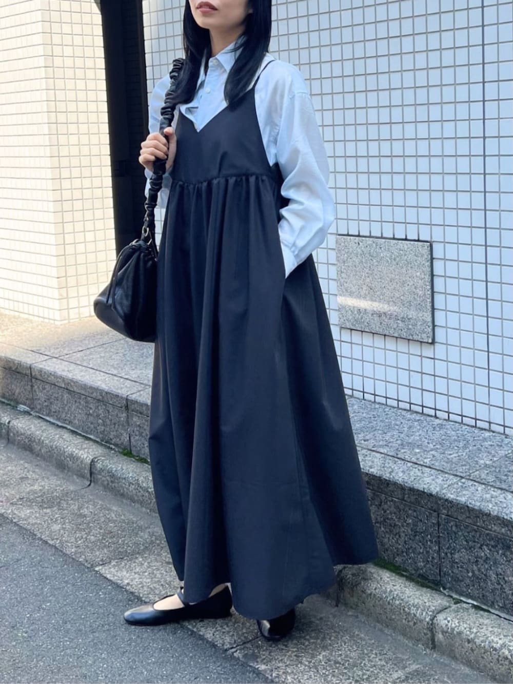 ブラック系のワンピース、ブルー系のシャツ/ブラウス、ブラック系のパンプスを着用したレディースの春コーディネートの4枚目の写真