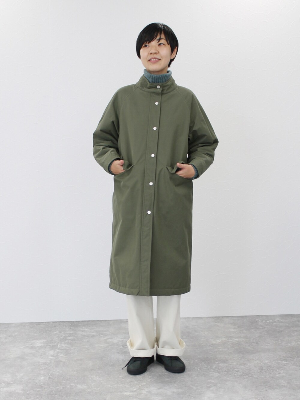 ホワイト系のパンツ、グリーン系のその他アウター、グリーン系のニット/セーターを着用したレディースの冬コーディネートの3枚目の写真