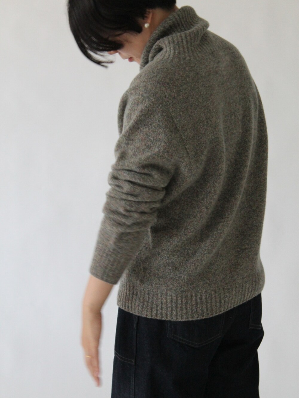 グレー系のニット/セーター、ブルー系のデニムパンツを着用したレディースの冬コーディネートの5枚目の写真