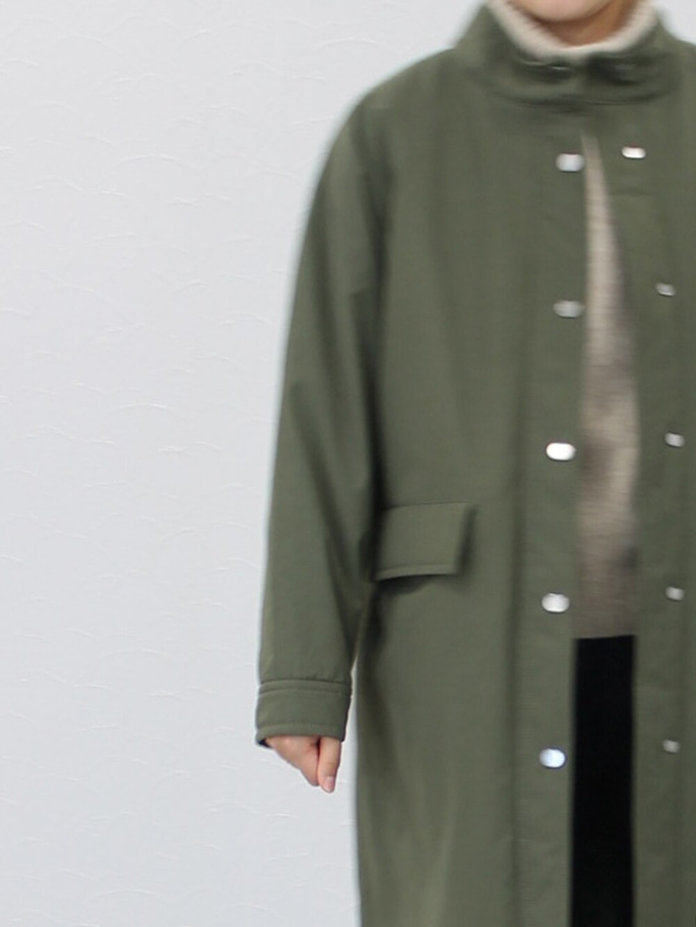 ベージュ系のニット/セーター、グリーン系のその他アウター、ブルー系のデニムパンツを着用したレディースの秋コーディネートの4枚目の写真