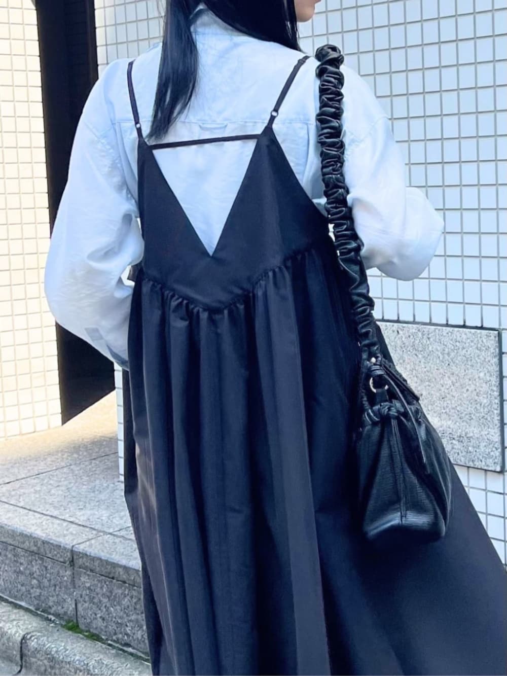 ブラック系のワンピース、ブルー系のシャツ/ブラウス、ブラック系のパンプスを着用したレディースの春コーディネートの6枚目の写真