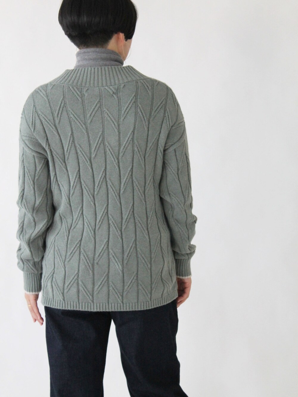 グリーン系のニット/セーター、ブルー系のデニムパンツ、ベージュ系のその他アウターを着用したレディースの秋コーディネートの5枚目の写真