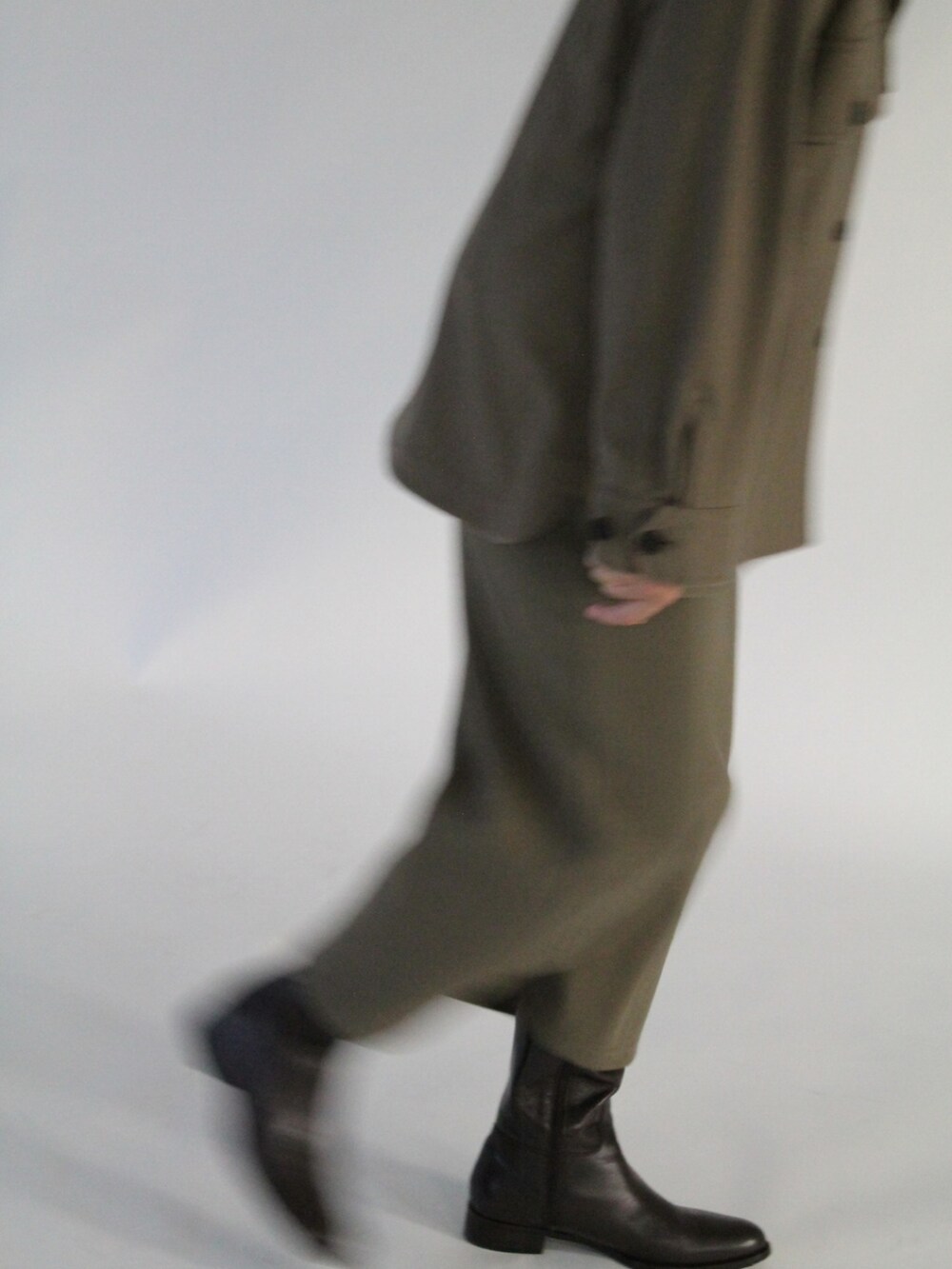 ブルー系のTシャツ/カットソー、ブラウン系のダウンジャケット/コート、グリーン系のスカートを着用したレディースの秋コーディネートの5枚目の写真