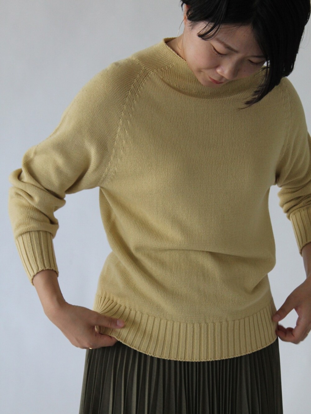 グリーン系のスカート、グリーン系のワンピース、イエロー系のニット/セーターを着用したレディースの冬コーディネートの5枚目の写真