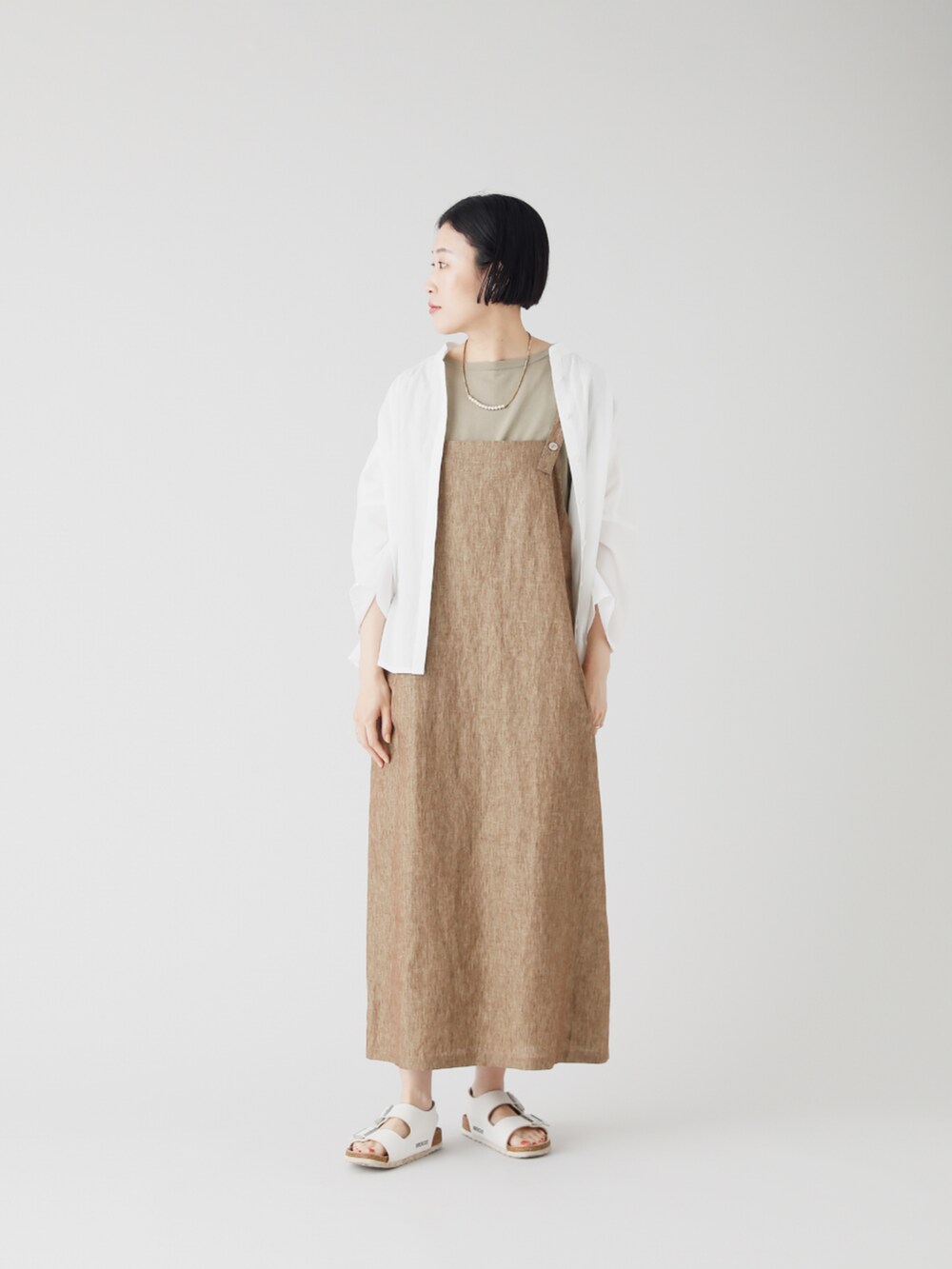 ホワイト系のシャツ/ブラウス、グリーン系のニット/セーター、ブラウン系のワンピースを着用したレディースの夏コーディネートの2枚目の写真