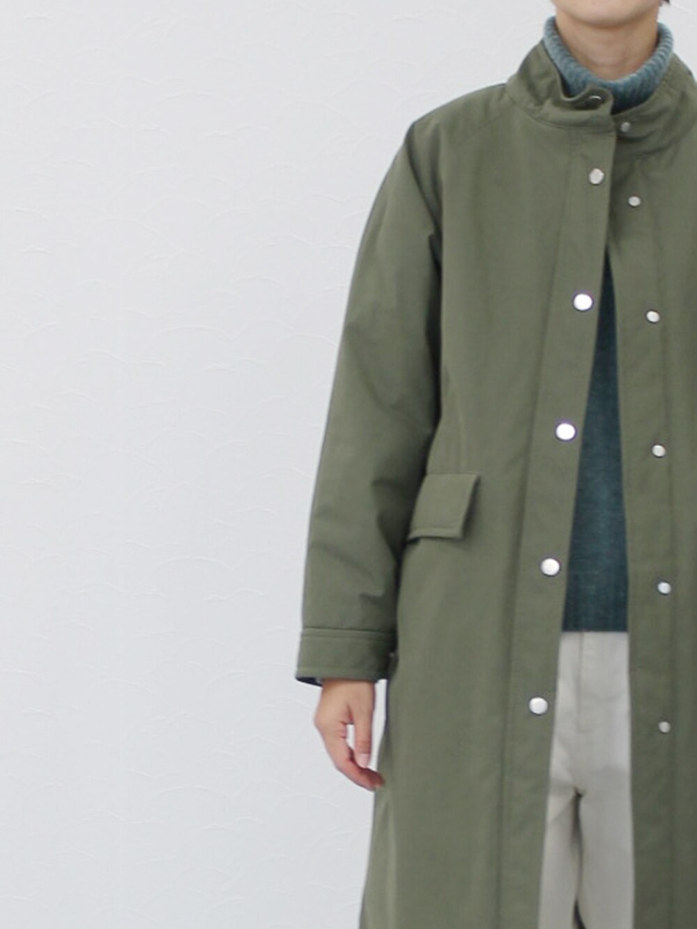 ホワイト系のパンツ、グリーン系のその他アウター、グリーン系のニット/セーターを着用したレディースの冬コーディネートの4枚目の写真