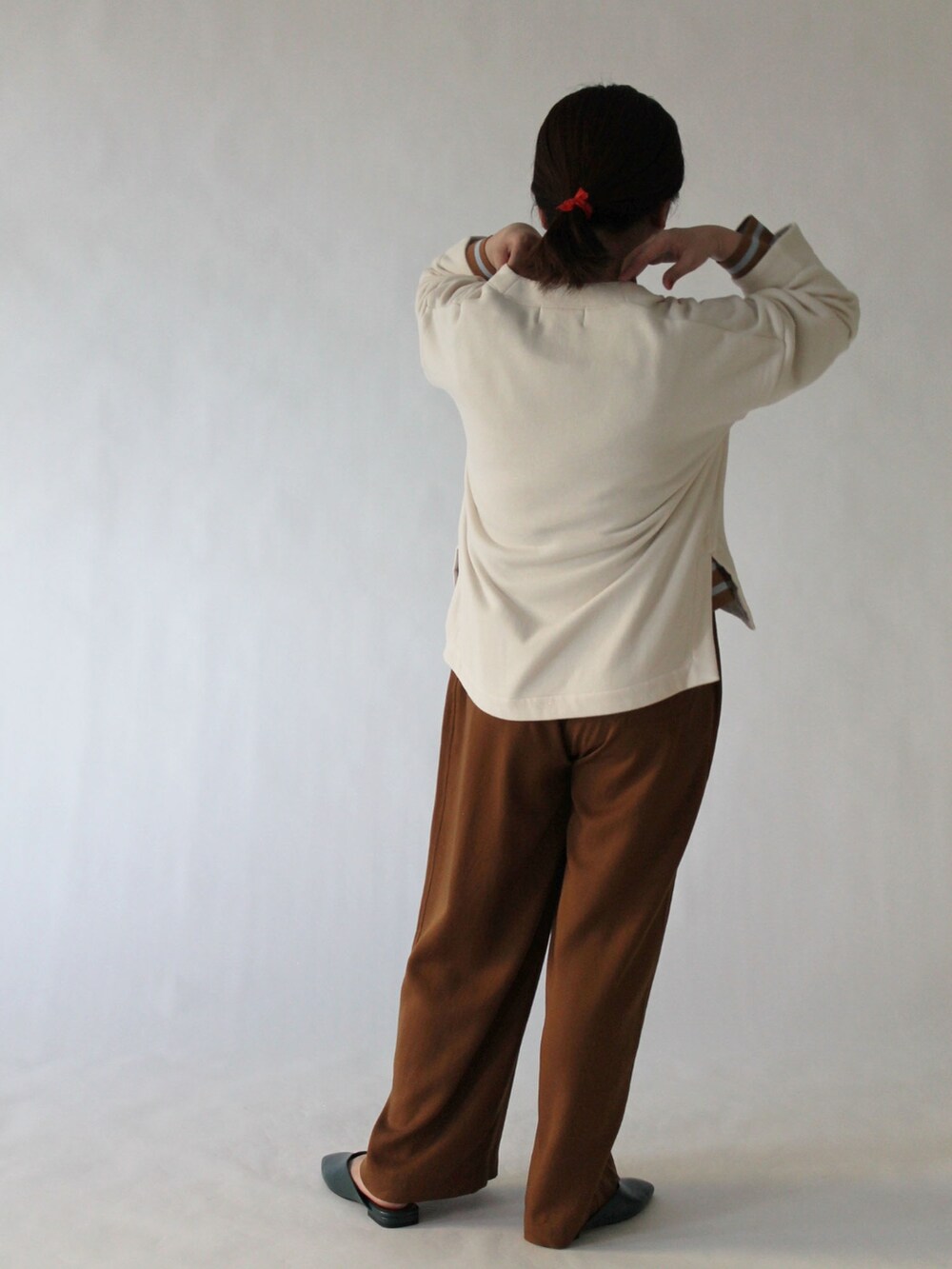 ベージュ系のスウェット、イエロー系のTシャツ/カットソー、ブラウン系のパンツを着用したレディースの春コーディネートの3枚目の写真