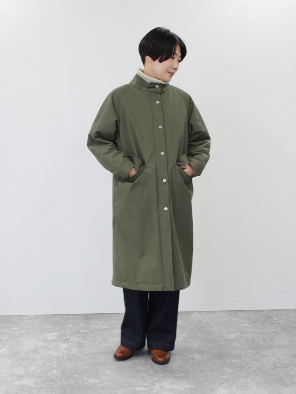 ベージュ系のニット/セーター、グリーン系のその他アウター、ブルー系のデニムパンツを着用したレディースの秋コーディネートの2枚目の写真