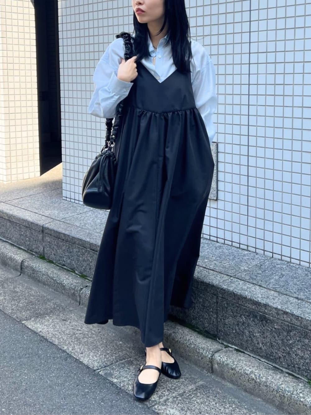 ブラック系のワンピース、ブルー系のシャツ/ブラウス、ブラック系のパンプスを着用したレディースの春コーディネートの3枚目の写真