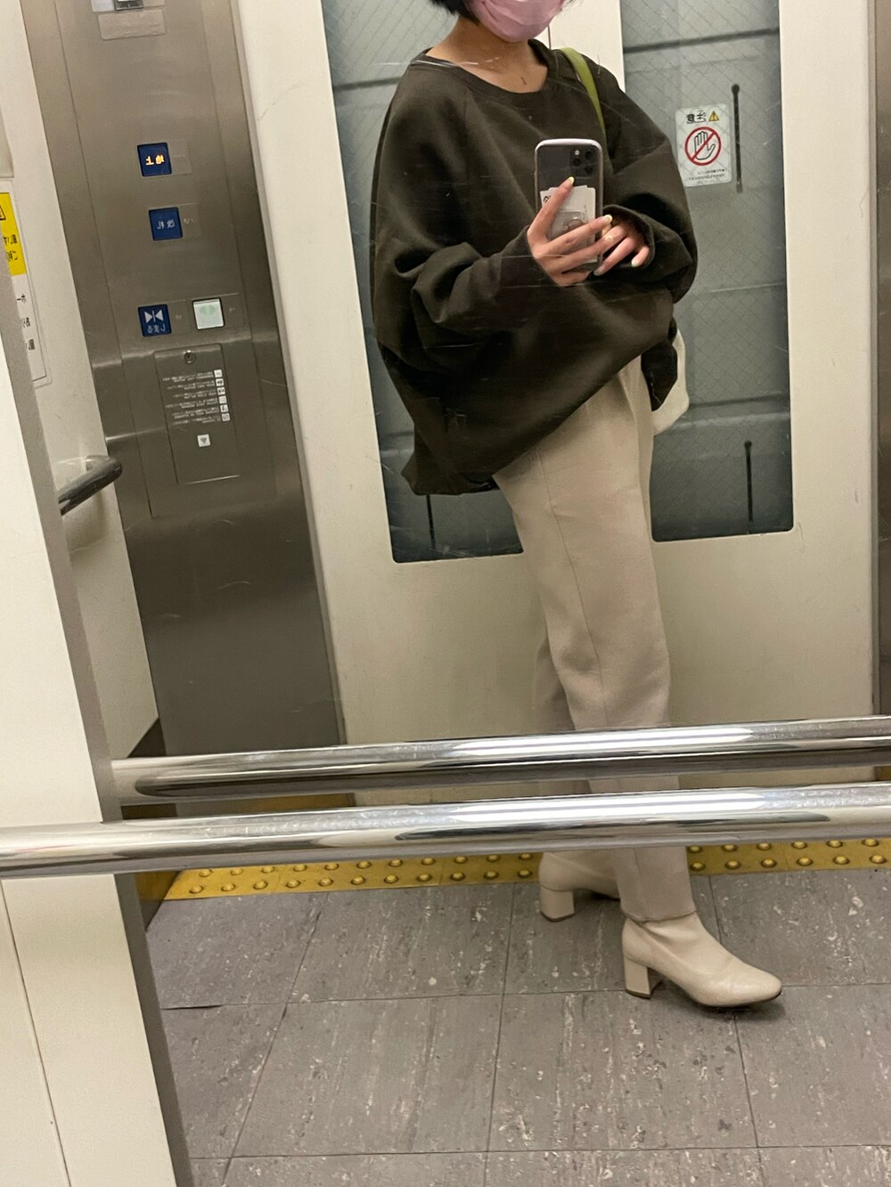 ブラウン系のトップス、ベージュ系のパンツ、ホワイト系のブーツを着用したレディースの春コーディネートの2枚目の写真