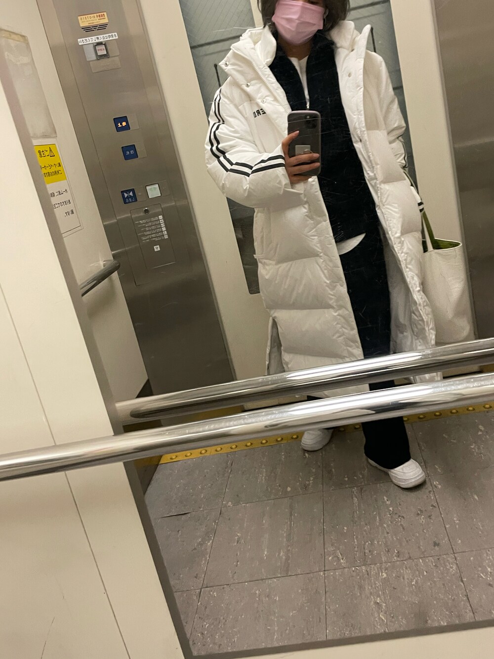 ホワイト系のTシャツ/カットソー、ブラック系のその他パンツ、ホワイト系のダウンジャケット/コートを着用したレディースの冬コーディネートの2枚目の写真