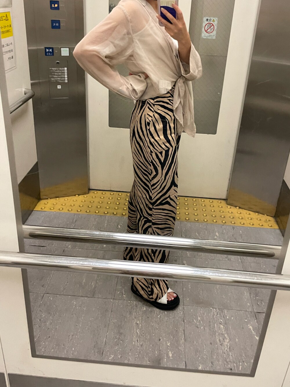 ベージュ系のシャツ/ブラウス、ホワイト系のタンクトップ、ブラウン系のパンツを着用したレディースの夏コーディネートの2枚目の写真