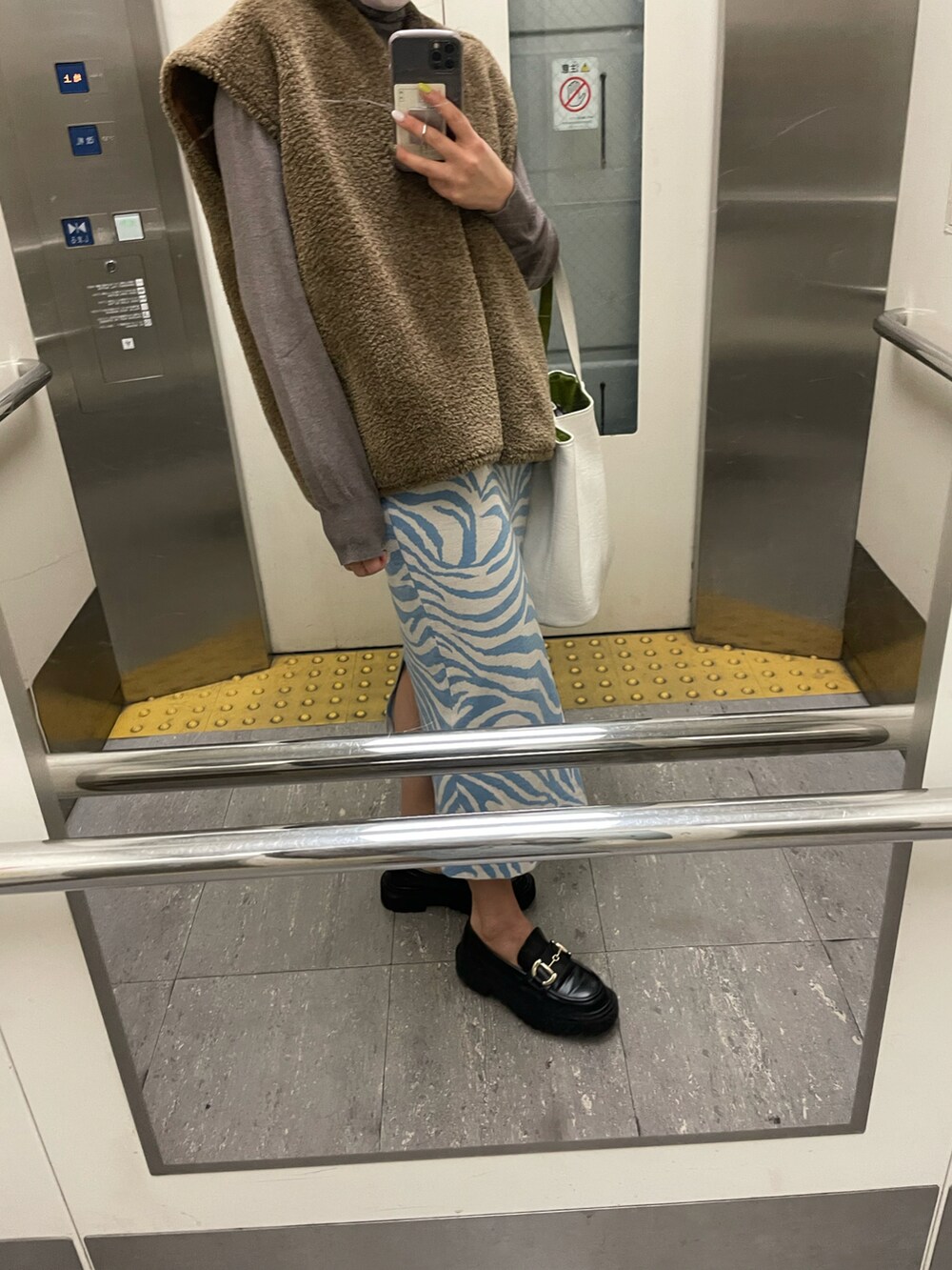 ブラウン系のジャケット/アウター、ブラック系のローファー、ブルー系のスカートを着用したレディースの春コーディネートの2枚目の写真