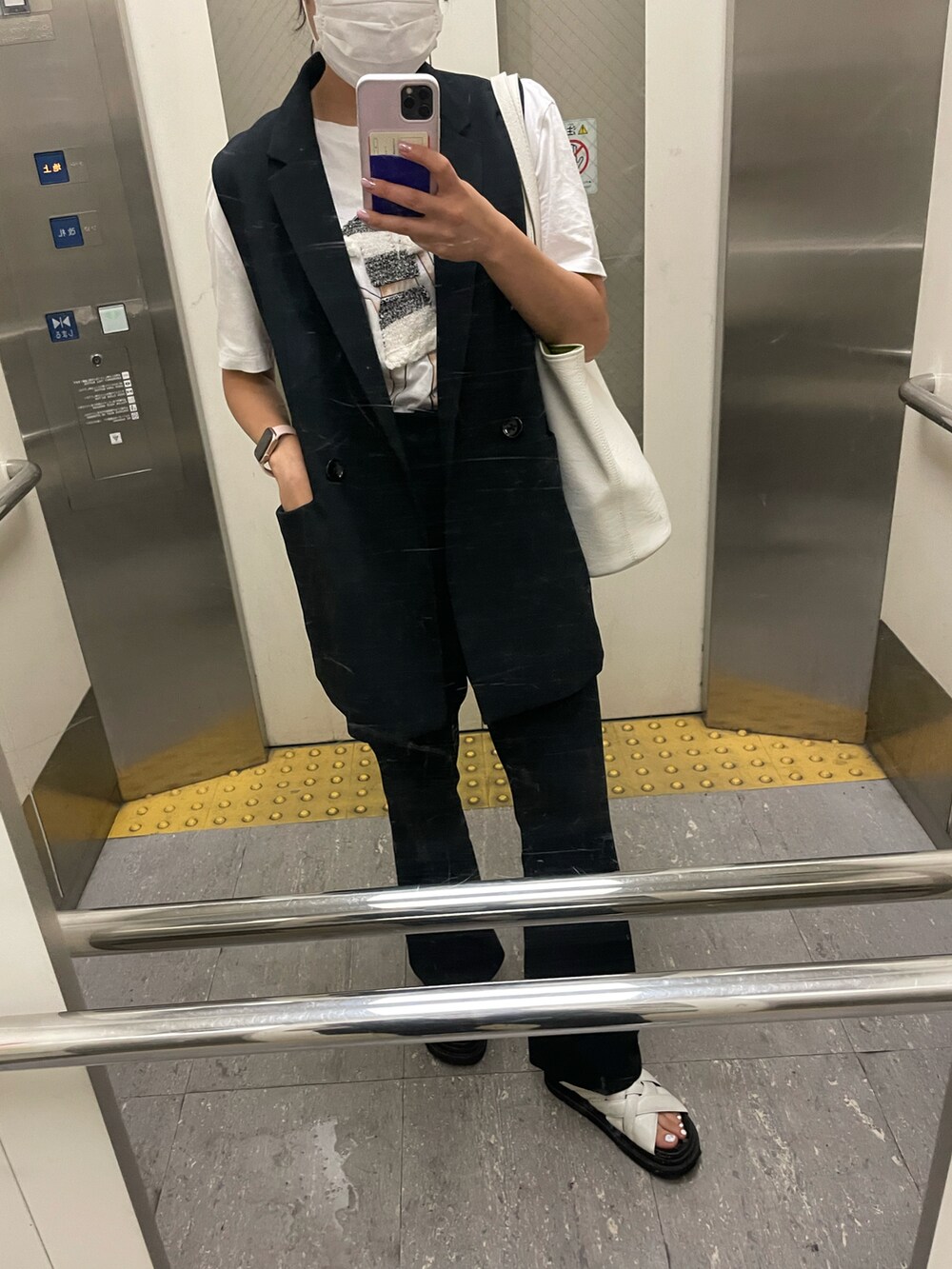 ブラック系のベスト、ホワイト系のTシャツ/カットソー、ブラック系のスラックスを着用したレディースの春コーディネートの2枚目の写真