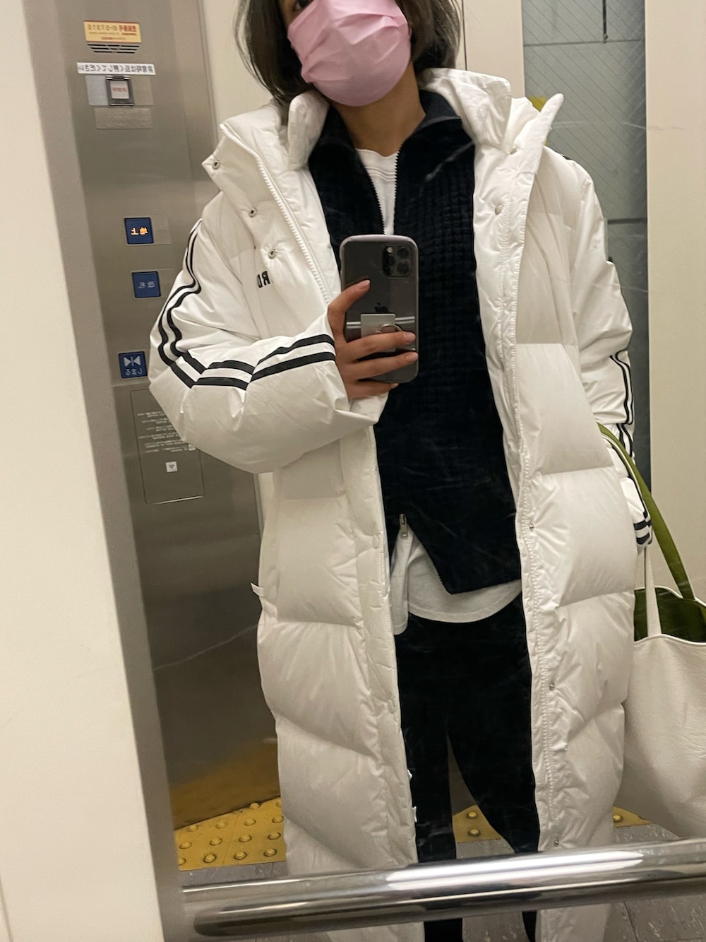 ホワイト系のTシャツ/カットソー、ブラック系のその他パンツ、ホワイト系のダウンジャケット/コートを着用したレディースの冬コーディネートの3枚目の写真