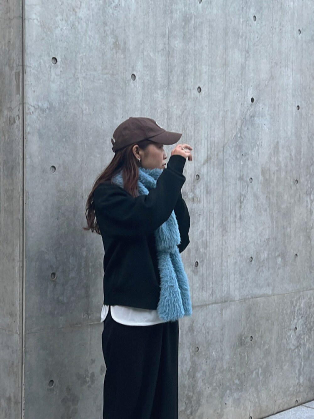 ブラック系のニット/セーター、ブラック系のパンツ、グレー系のスニーカーを着用したレディースの秋コーディネートの4枚目の写真