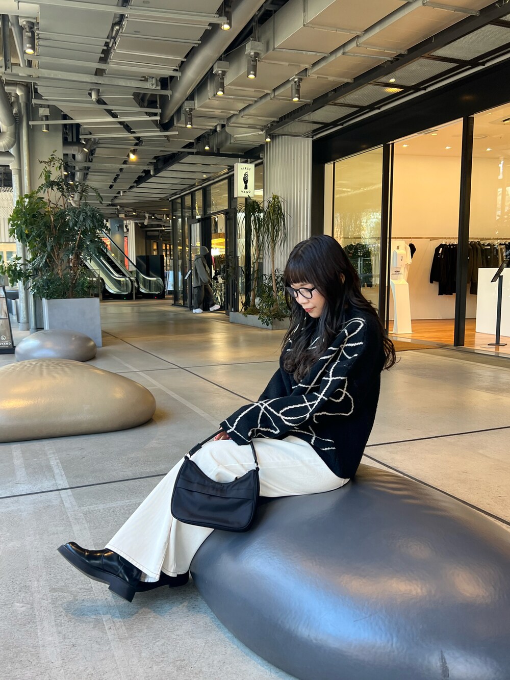 ブラック系のニット/セーター、ブラック系のハンドバッグを着用したレディースの冬コーディネートの4枚目の写真