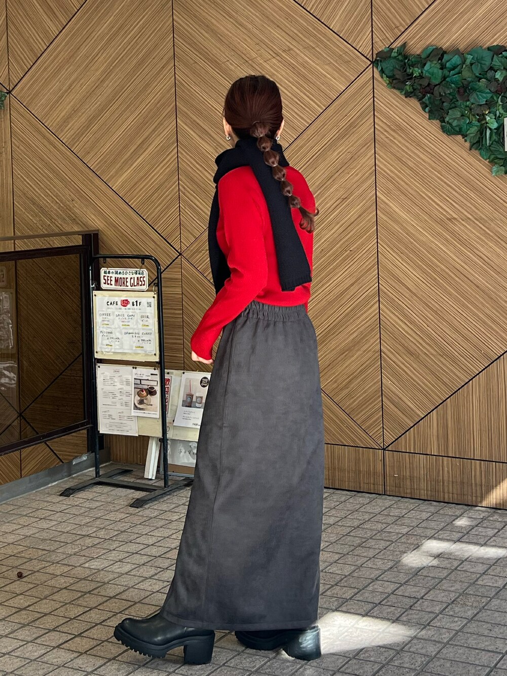 ブラック系のドラムバッグ、レッド系のニット/セーター、ブラック系のスカートを着用したレディースの秋コーディネートの5枚目の写真