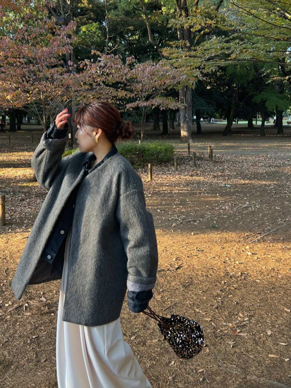 ブラウン系のショルダーバッグ、グレー系のノーカラーコート、ブルー系のデニムジャケットを着用したレディースの秋コーディネートの5枚目の写真