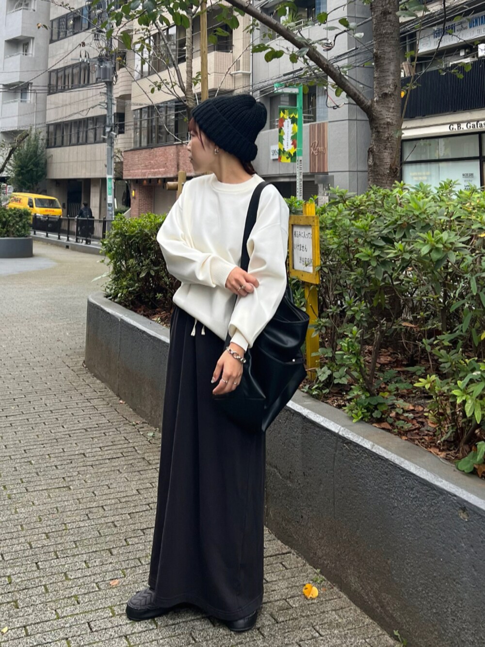 ホワイト系のニット/セーター、ブラック系のスカート、ブラック系のショルダーバッグを着用したレディースの秋コーディネートの2枚目の写真
